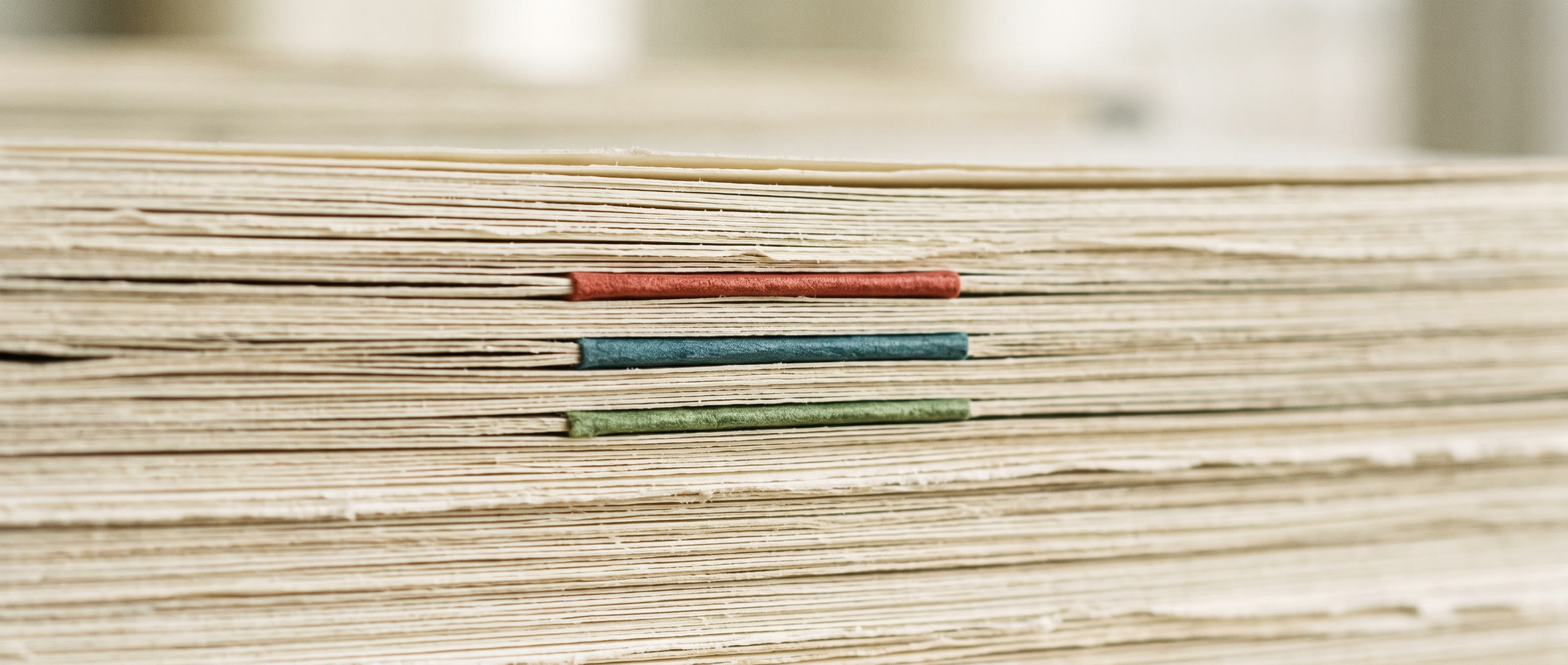 Bordo pagina di una pila di fascicoli, con i tre colori di professione